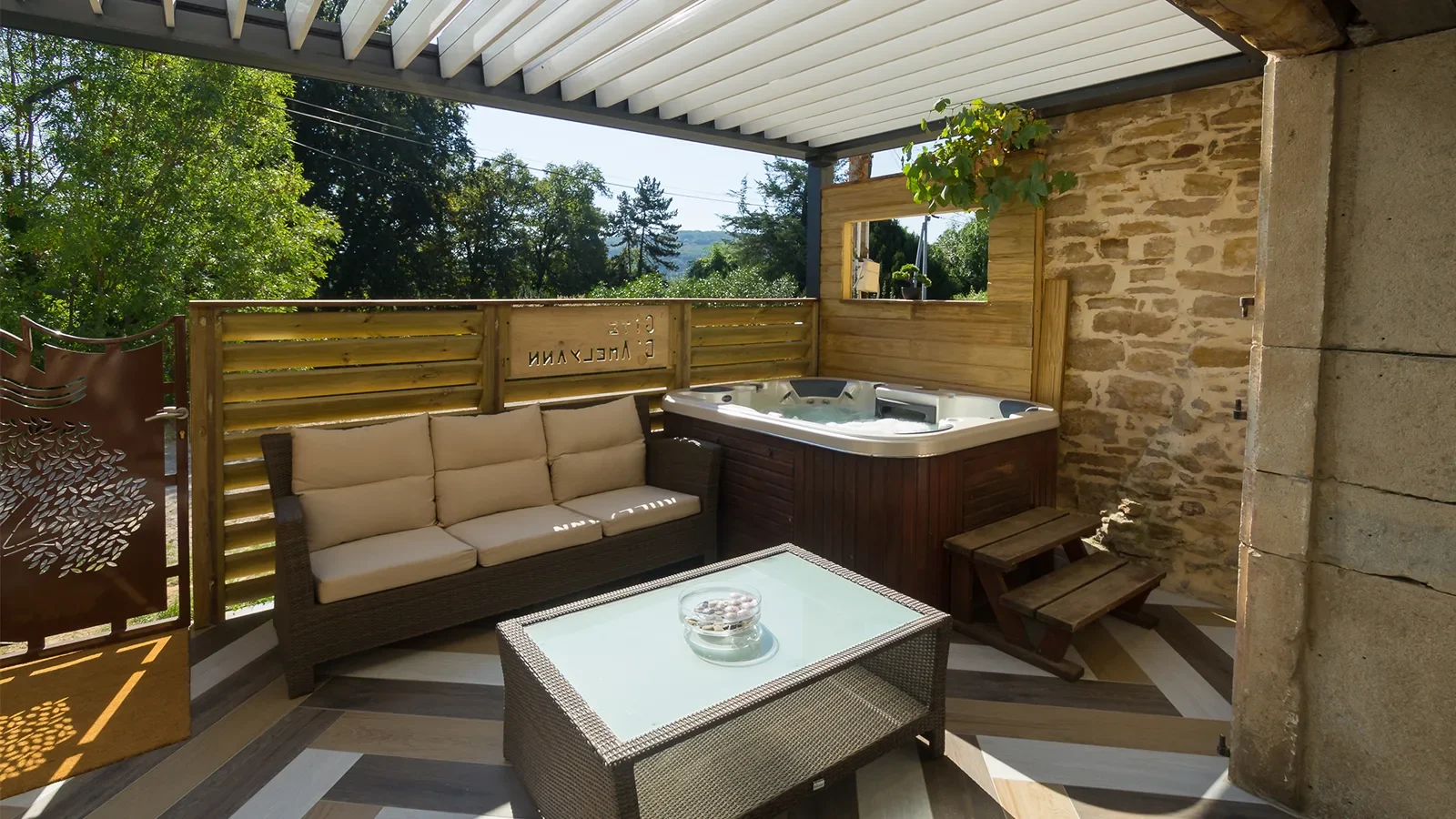 Terrasse du meublé Amel Yann avec jacuzzi et salon de jardin, hébergements pour un séjour romantique