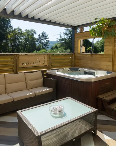 Terrasse du meublé Amel Yann avec jacuzzi et salon de jardin, hébergements pour un séjour romantique